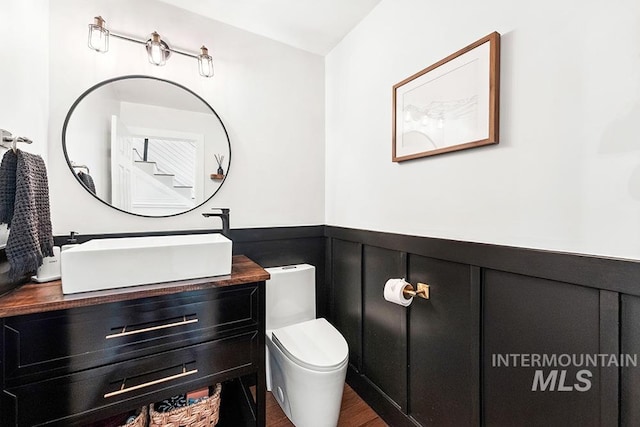 1866 S Goldking Way, Boise, ID 83709 - half bath with vanity, wainscoting, toilet, wood finished floors, and a decorative wall