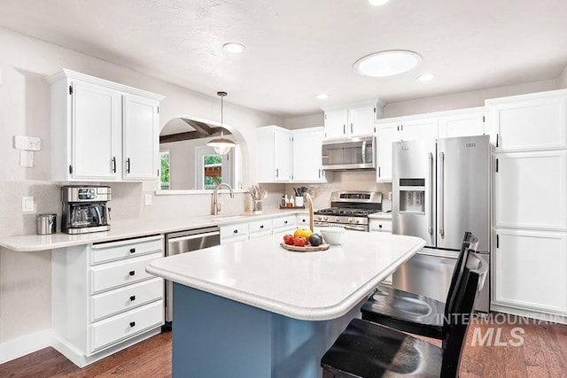 1866 S Goldking Way, Boise, ID 83709 - kitchen with stainless steel appliances, a sink, a breakfast bar area, arched walkways, and light countertops