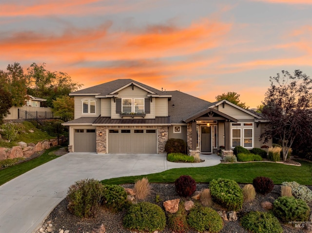 craftsman house featuring a garage and a lawn