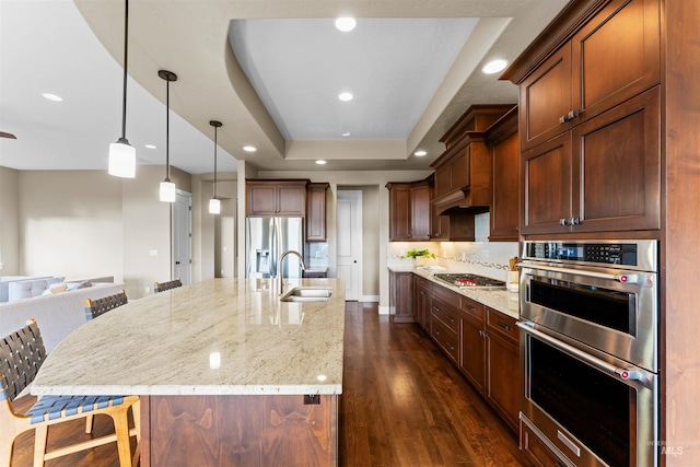 kitchen featuring a spacious island, sink, a kitchen breakfast bar, and dark hardwood / wood-style flooring