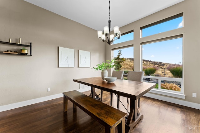 dining space featuring hardwood / wood-style flooring and a chandelier