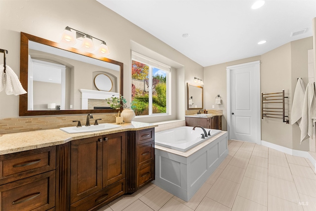 bathroom featuring vanity, tasteful backsplash, a washtub, and tile patterned flooring