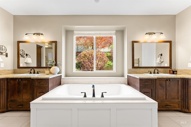 bathroom with vanity, a bathing tub, and tile patterned flooring