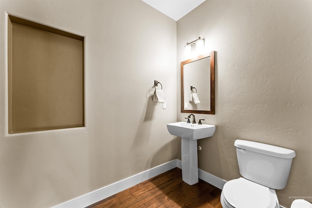 bathroom featuring hardwood / wood-style flooring and toilet