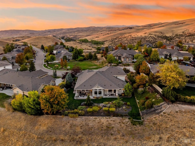 aerial view at dusk featuring a mountain view