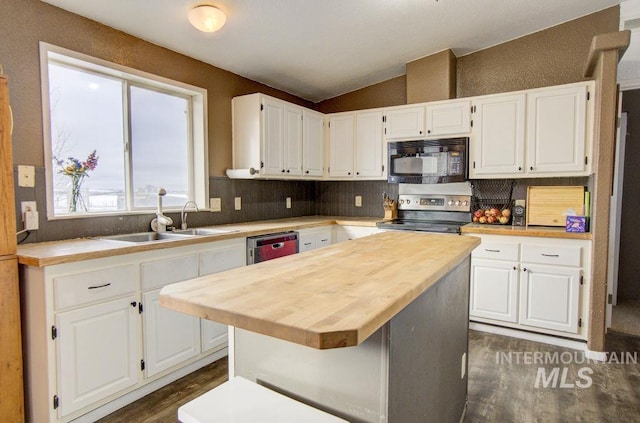 kitchen featuring stainless steel range with electric stovetop, white cabinetry, a center island, wood counters, and vaulted ceiling