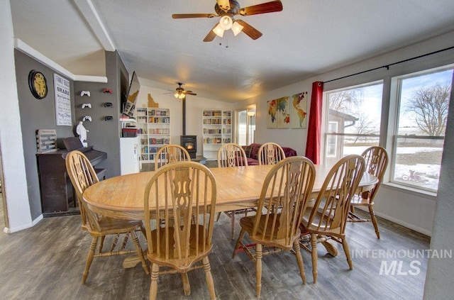 dining space featuring wood-type flooring and a wood stove