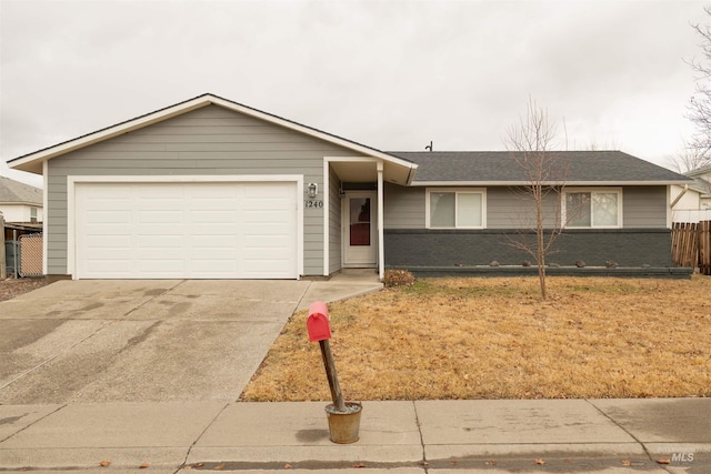 single story home with roof with shingles, brick siding, an attached garage, fence, and driveway