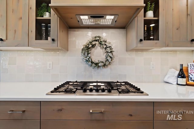 kitchen with stainless steel gas cooktop, light countertops, gray cabinets, and decorative backsplash