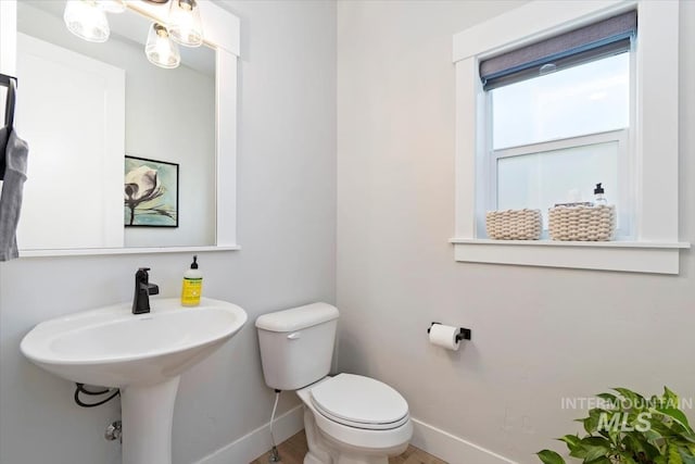 bathroom with baseboards and toilet
