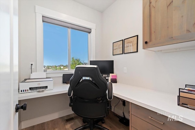 home office with dark wood-style flooring and built in study area