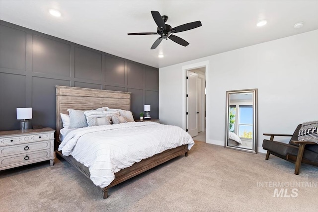 bedroom with a decorative wall, light colored carpet, recessed lighting, and a ceiling fan