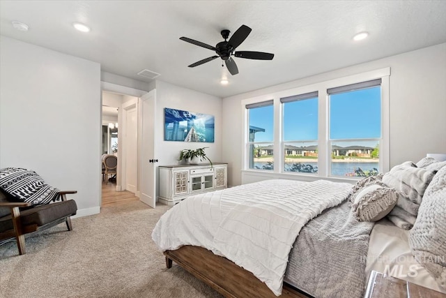 bedroom featuring carpet flooring, baseboards, a water view, a ceiling fan, and recessed lighting