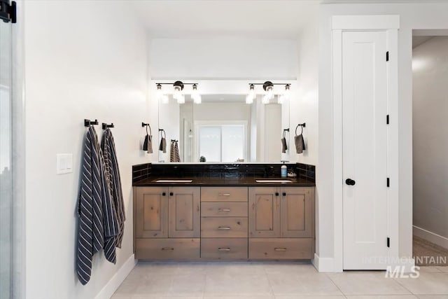 full bathroom featuring double vanity, baseboards, and tile patterned floors