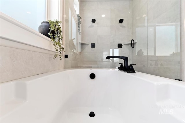 full bathroom featuring a tub to relax in and a shower