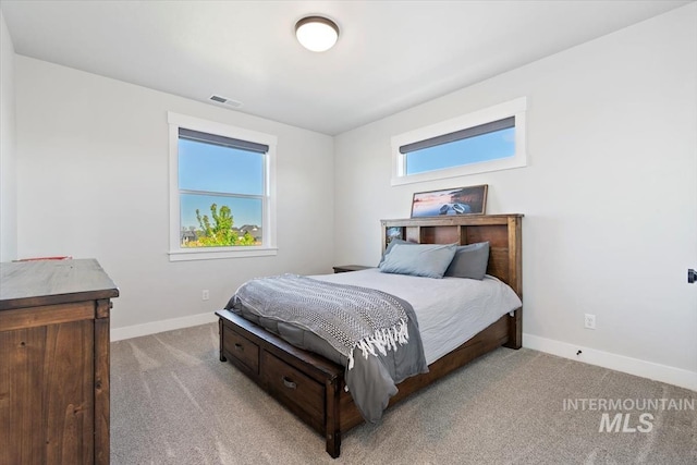 bedroom with light carpet and baseboards