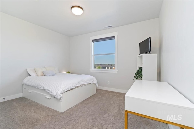 bedroom featuring light carpet and baseboards