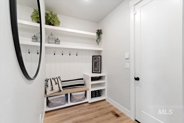 mudroom with wood finished floors and baseboards