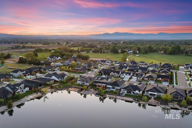 aerial view at dusk of a water and mountain view and a residential view