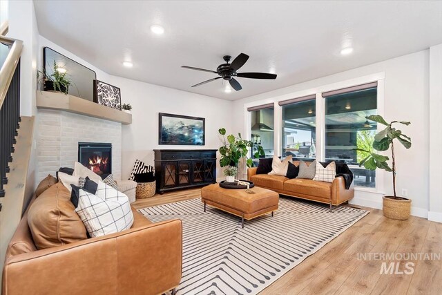 living area featuring wood finished floors, a ceiling fan, a fireplace, recessed lighting, and baseboards
