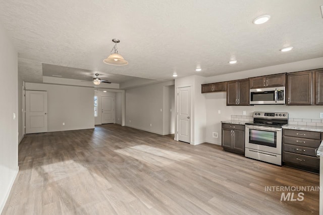 kitchen featuring a textured ceiling, appliances with stainless steel finishes, light wood-type flooring, and dark brown cabinetry