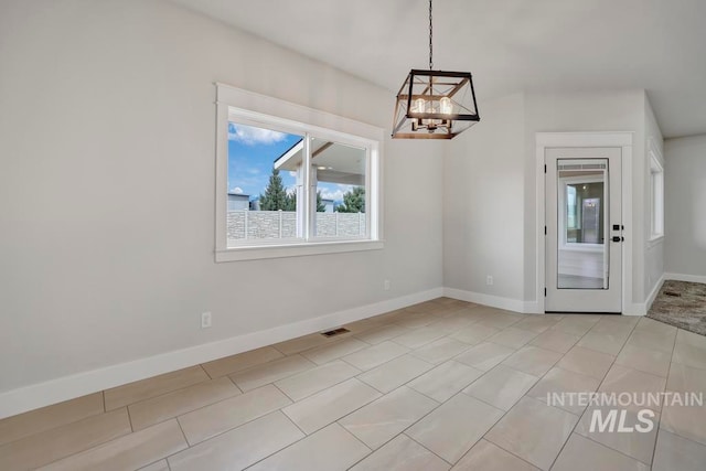 unfurnished dining area with light tile patterned floors, visible vents, and baseboards