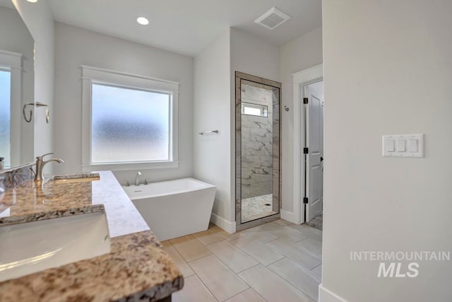 full bathroom with double vanity, a shower stall, visible vents, and a sink