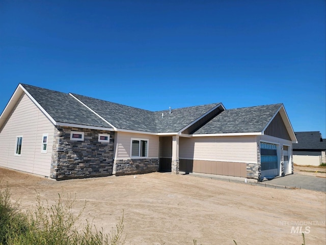 view of front of property with a garage and stone siding