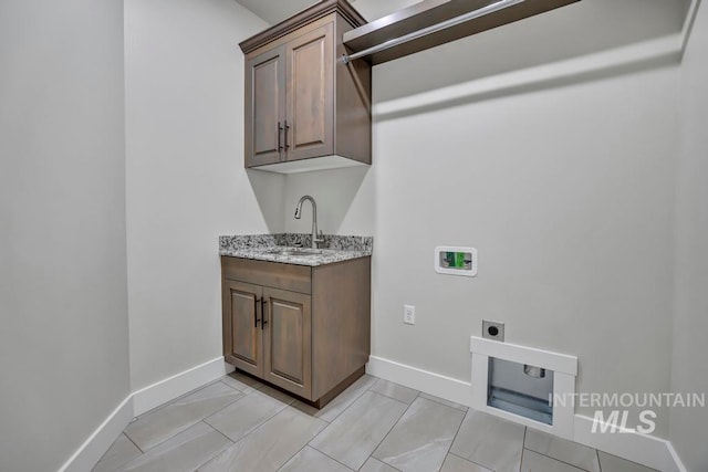 laundry room with a sink, hookup for a washing machine, electric dryer hookup, and baseboards