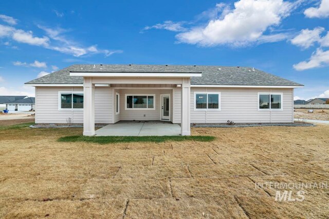 rear view of house featuring a yard and a patio