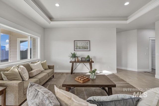 living area featuring baseboards, a tray ceiling, and recessed lighting