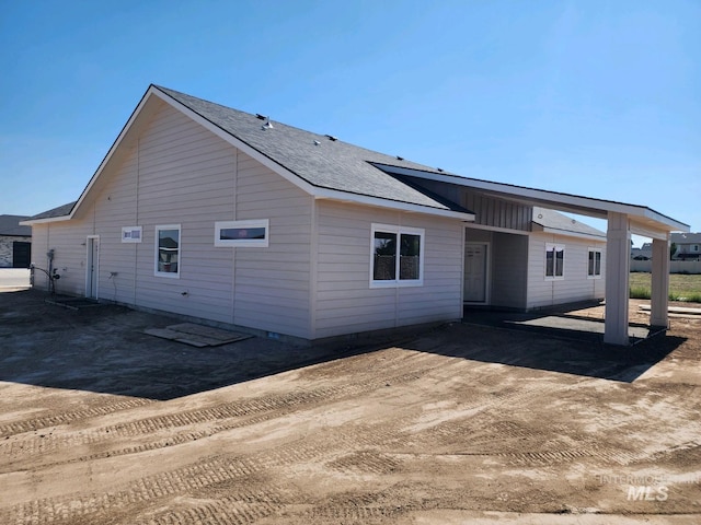 rear view of property featuring a shingled roof