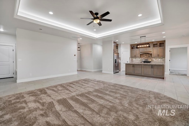 unfurnished living room with recessed lighting, a raised ceiling, ceiling fan, and light tile patterned floors