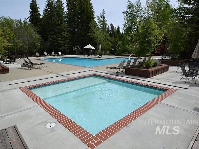 1319 Hearthstone Ct Unit 3-A, Mccall, ID 83638 - community pool featuring a patio area, fence, and view of scattered trees