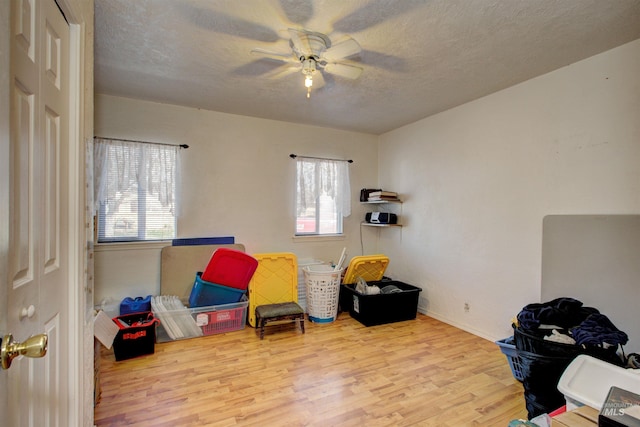 playroom with baseboards, wood finished floors, a textured ceiling, and ceiling fan