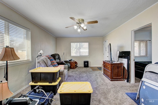 carpeted bedroom featuring a ceiling fan and a textured ceiling