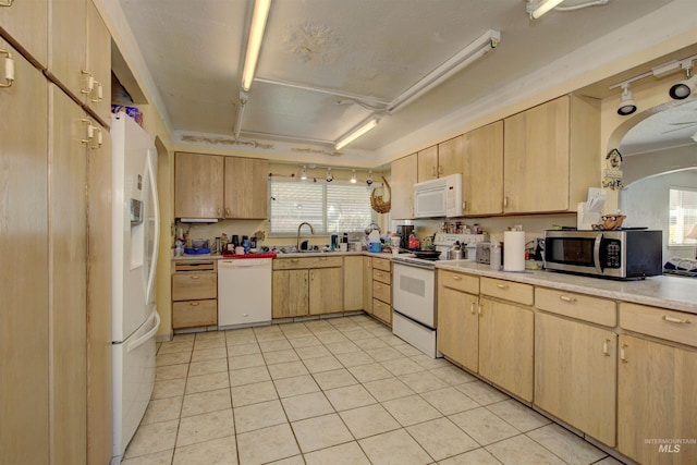 kitchen with light brown cabinetry, a sink, white appliances, light countertops, and light tile patterned floors