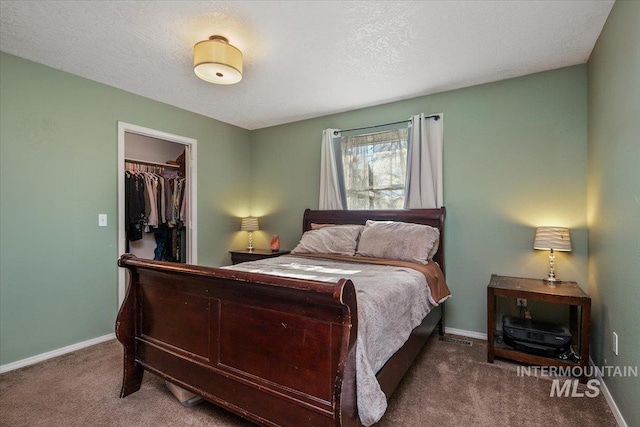 carpeted bedroom featuring a textured ceiling, a spacious closet, and a closet