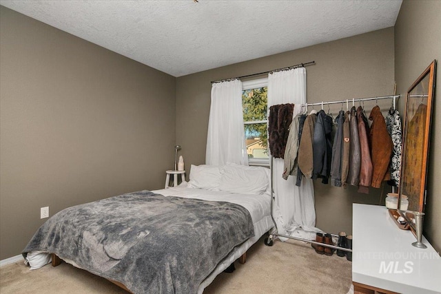 bedroom with a textured ceiling and carpet