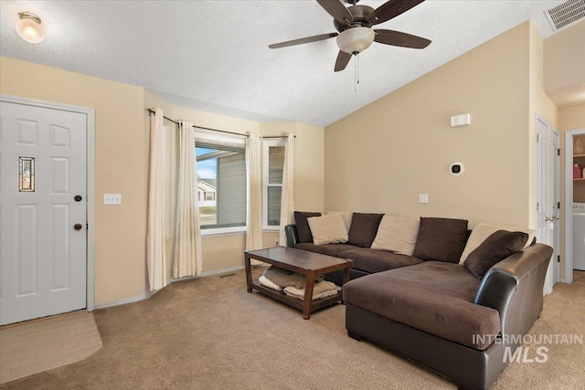 living room with ceiling fan, vaulted ceiling, light carpet, and a textured ceiling