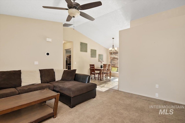 carpeted living room with lofted ceiling and ceiling fan with notable chandelier