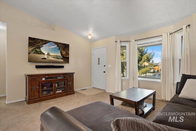 living room featuring a textured ceiling, light carpet, and vaulted ceiling