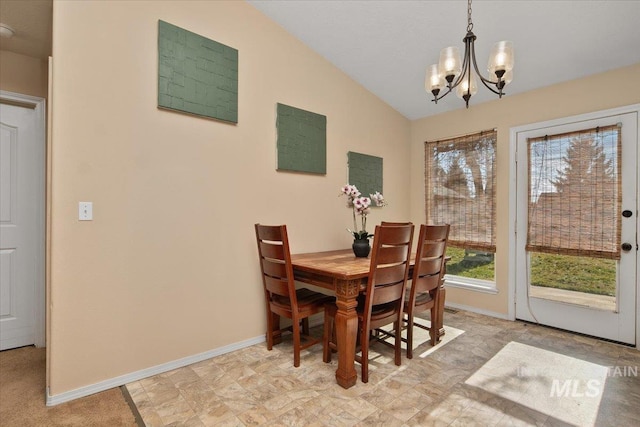 dining space with vaulted ceiling and a notable chandelier