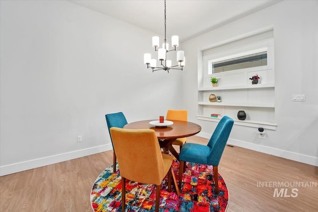 dining space with an inviting chandelier and light hardwood / wood-style floors