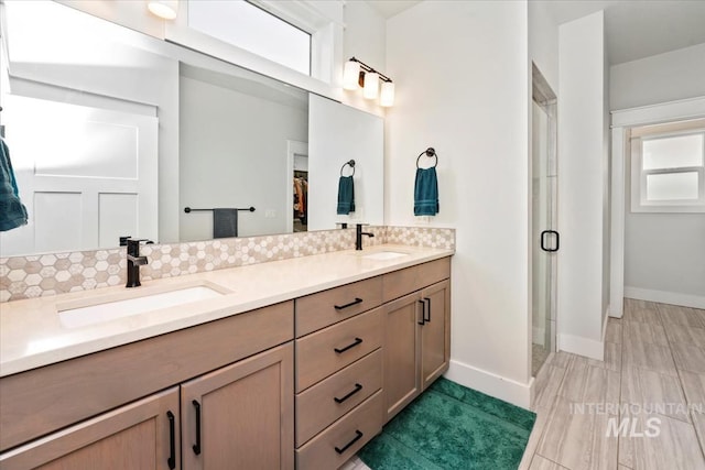 bathroom with vanity, an enclosed shower, and decorative backsplash