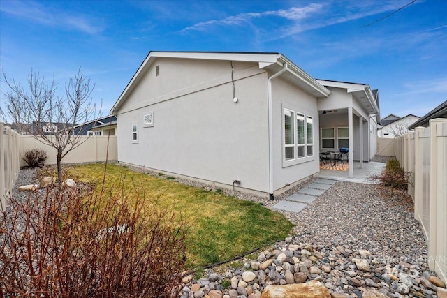 view of side of home featuring a yard and a patio