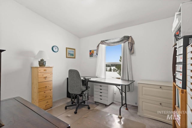 home office with vaulted ceiling and light carpet