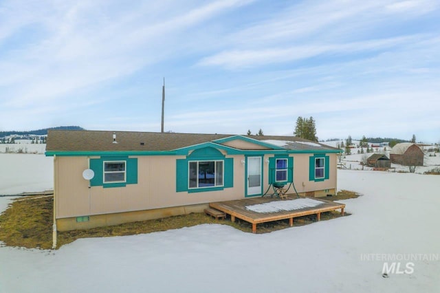 snow covered rear of property featuring crawl space