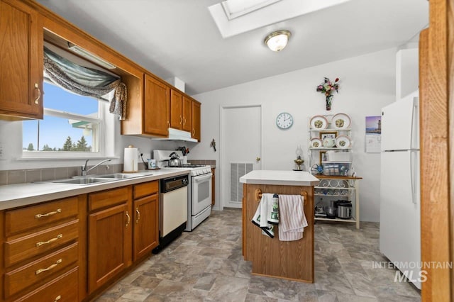 kitchen with a skylight, light countertops, visible vents, a sink, and white appliances