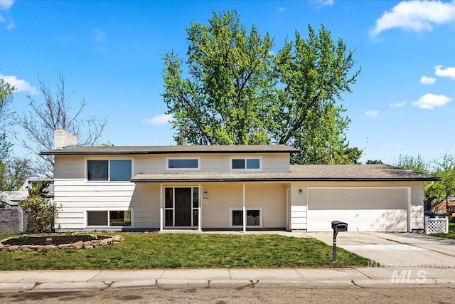 view of front of home with an attached garage, a chimney, a front yard, and concrete driveway